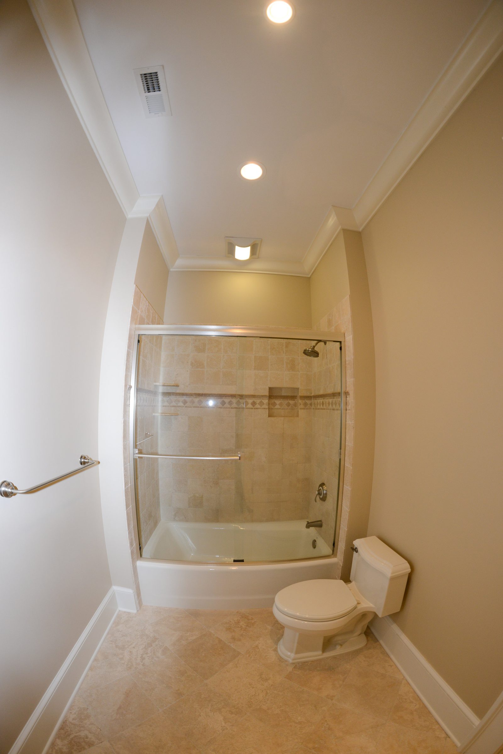 A guest bathroom with a corner shower and tiled surround