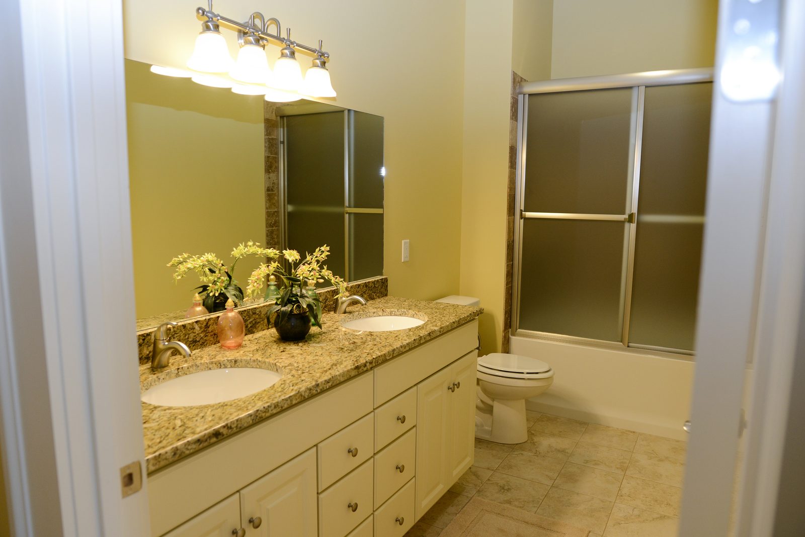 A guest bathroom with a double-basin vanity and a glass shower
