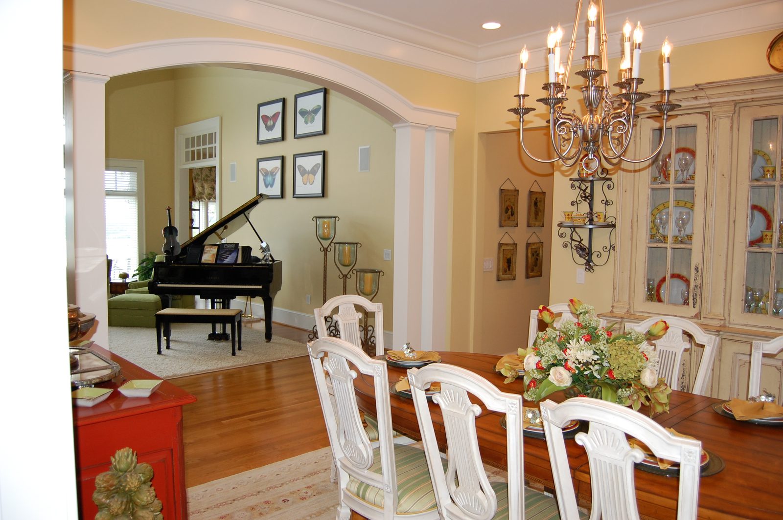 The dining area with a chandelier and a view through to the piano room