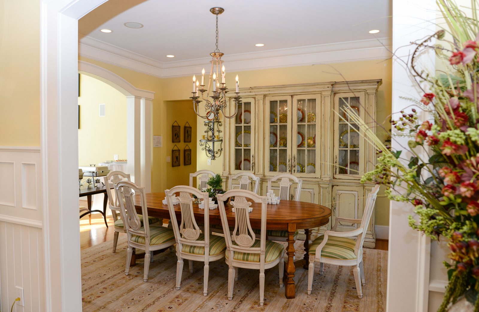 A formal dining room with an oval table, upholstered chairs and a chandelier (view 1)
