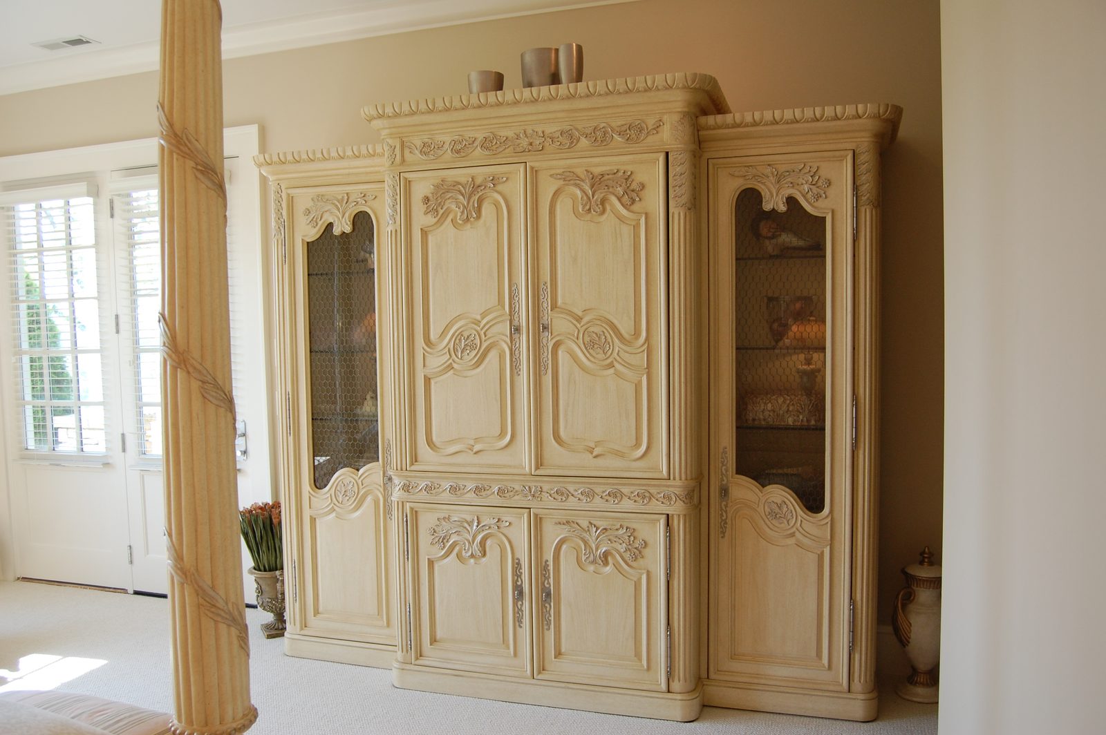 An entry area with a tall carved armoire beside the front door