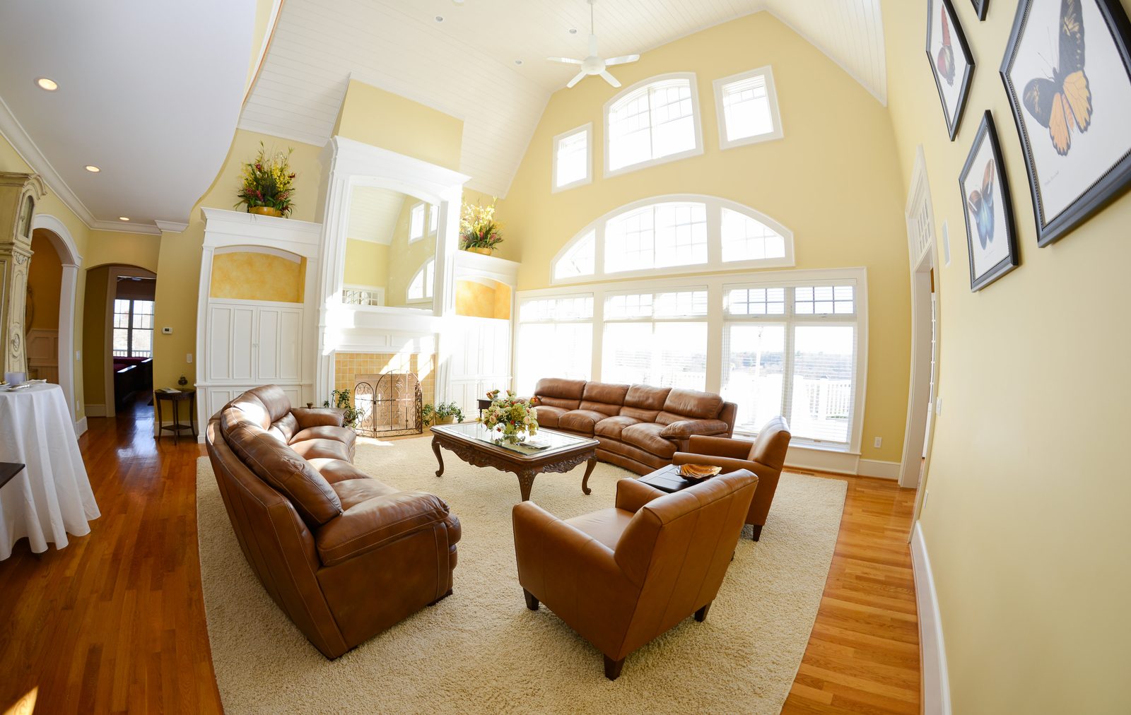 The two-story great room with leather sofas, a soft rug and a wall of windows (view 3)