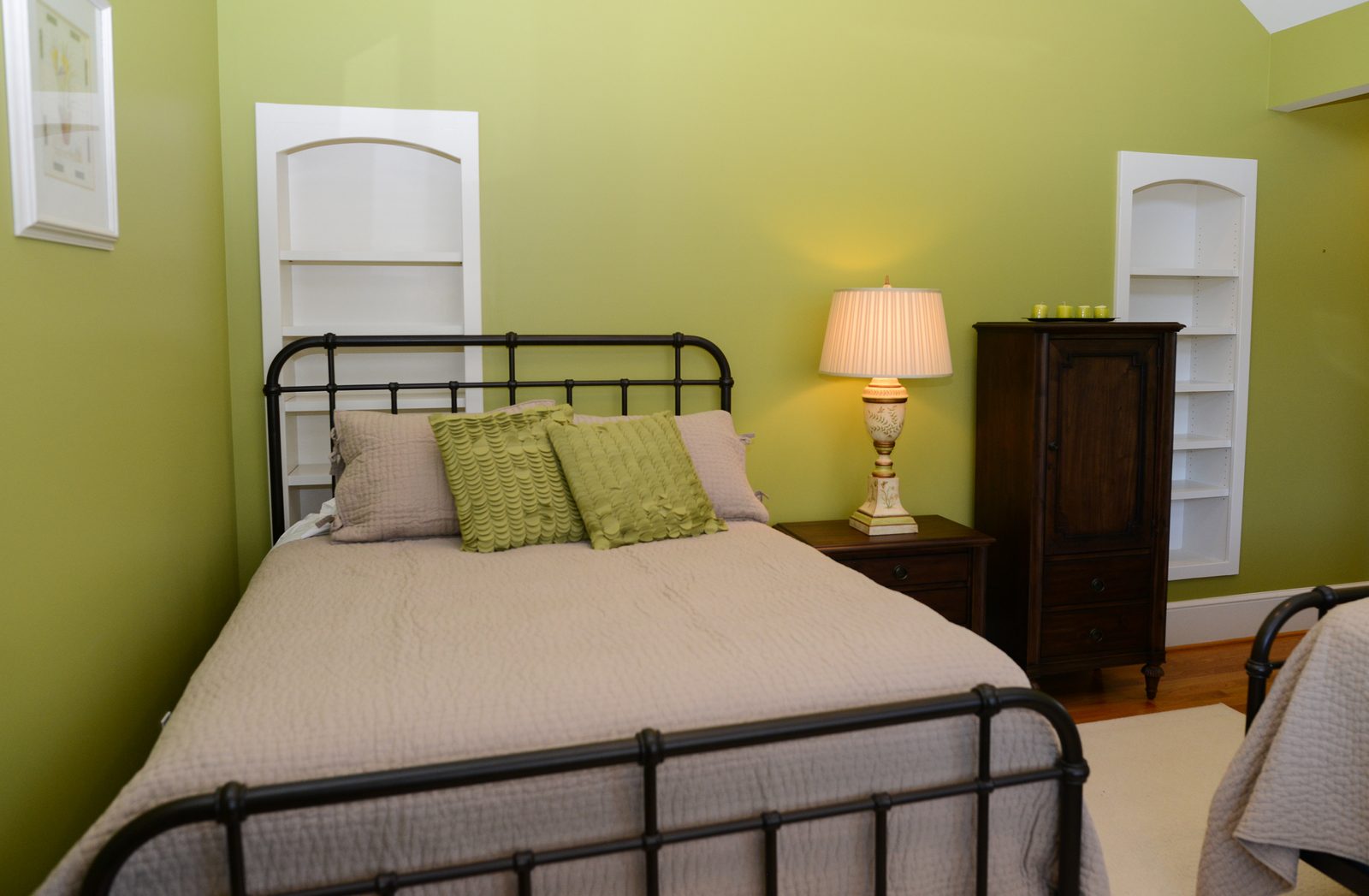 A guest room with an iron bed, green walls and a valanced window (view 4)