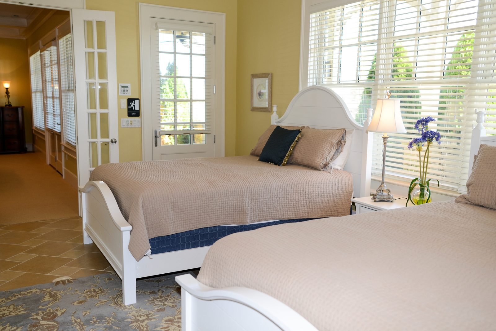 A guest room with two white beds, neutral linens and shuttered windows (view 4)