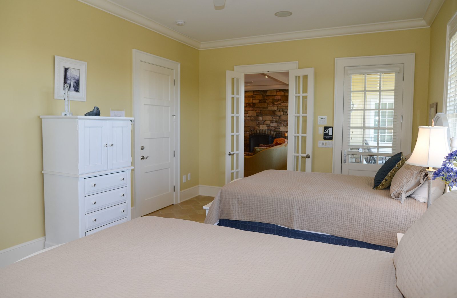 A guest room with two white beds, neutral linens and shuttered windows (view 5)