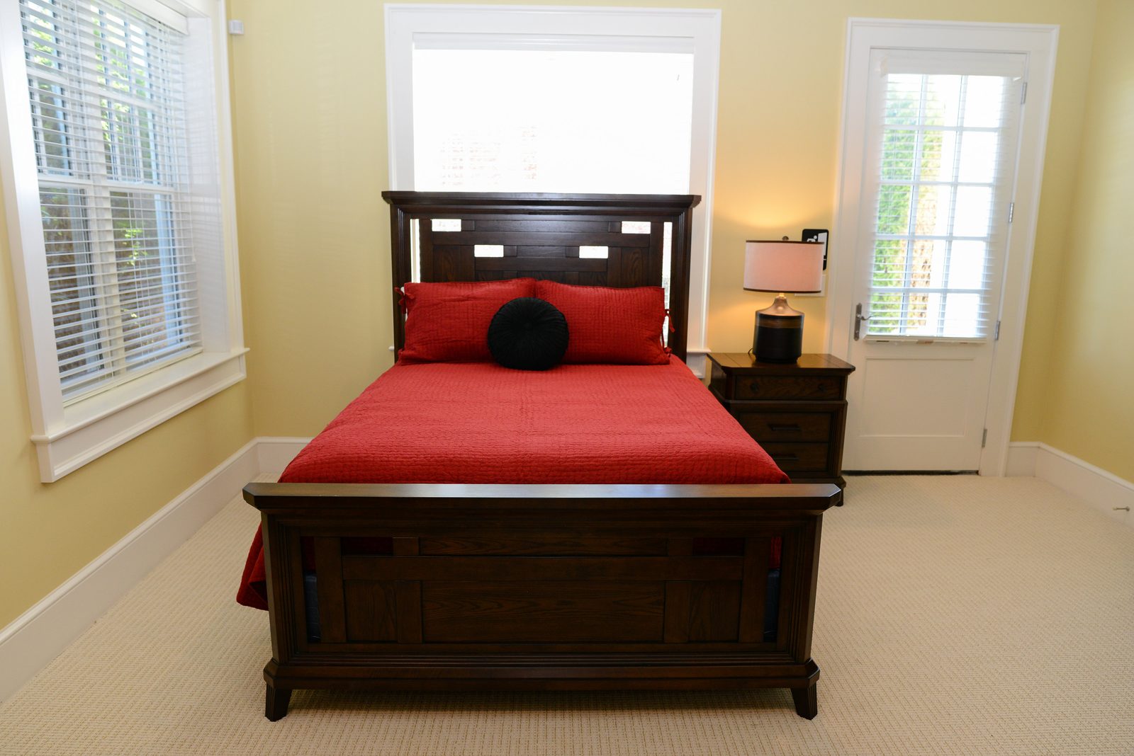 A guest room with red-linened beds, a column detail and a round area rug (view 3)