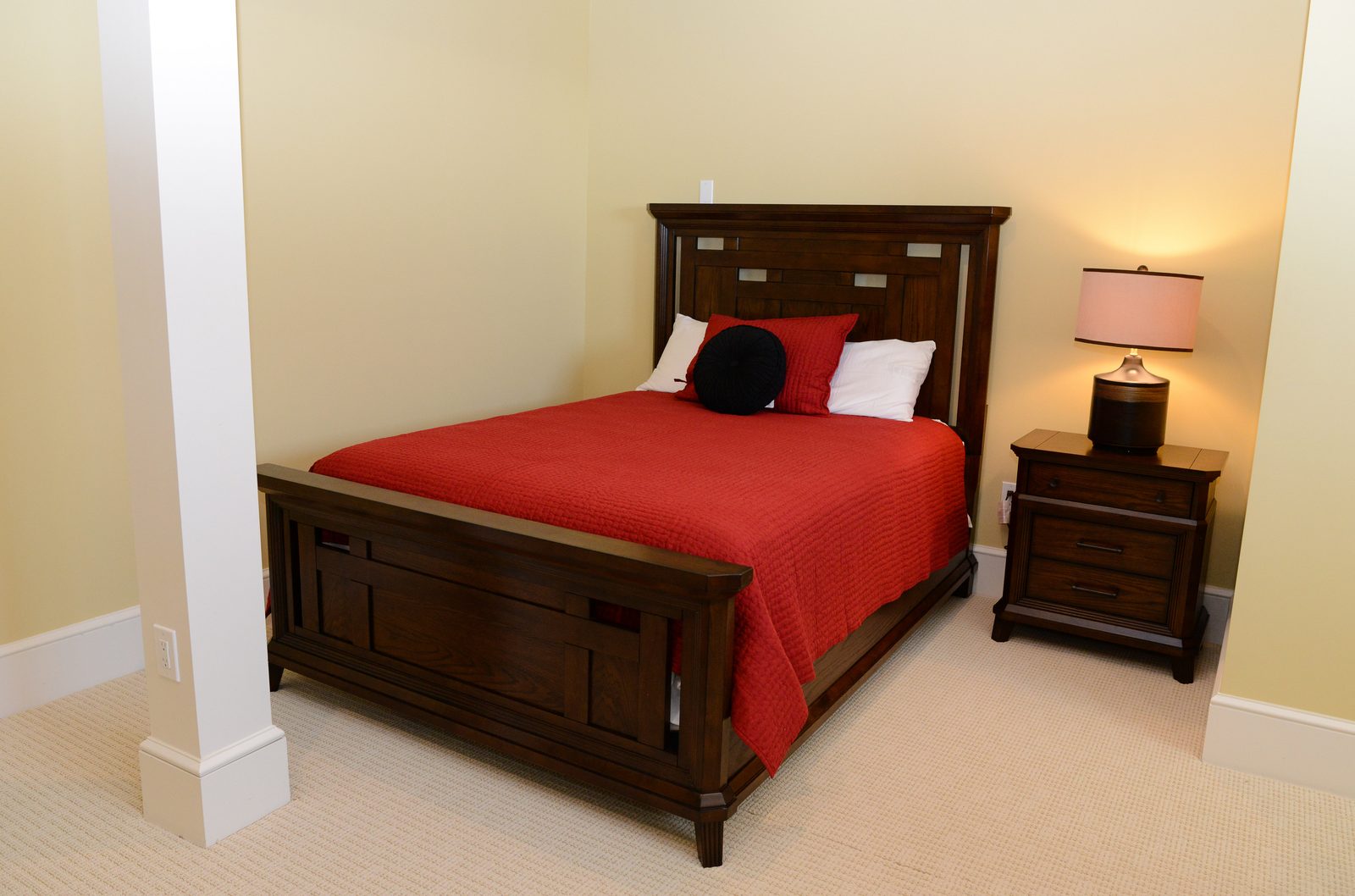 A guest room with red-linened beds, a column detail and a round area rug (view 5)