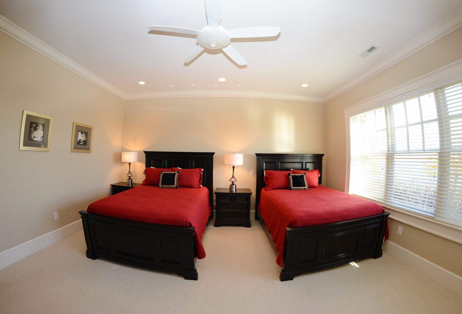 A guest room with two dark wood beds in red linens beneath a coffered ceiling (view 3)