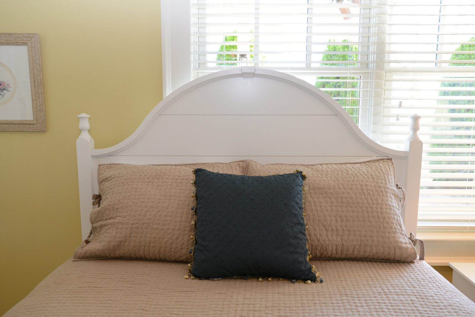 A guest room with a taupe-linened bed, fresh flowers and shuttered windows (view 3)