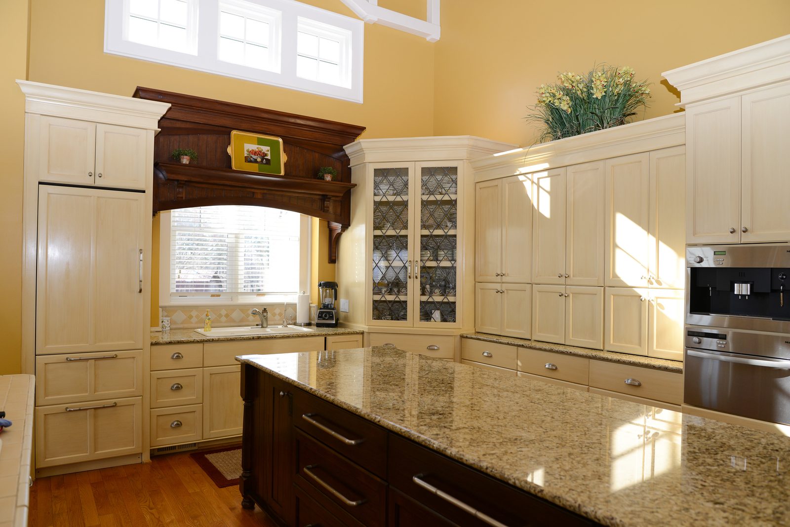 The main kitchen with cream cabinetry, a granite island and stainless appliances (view 3)