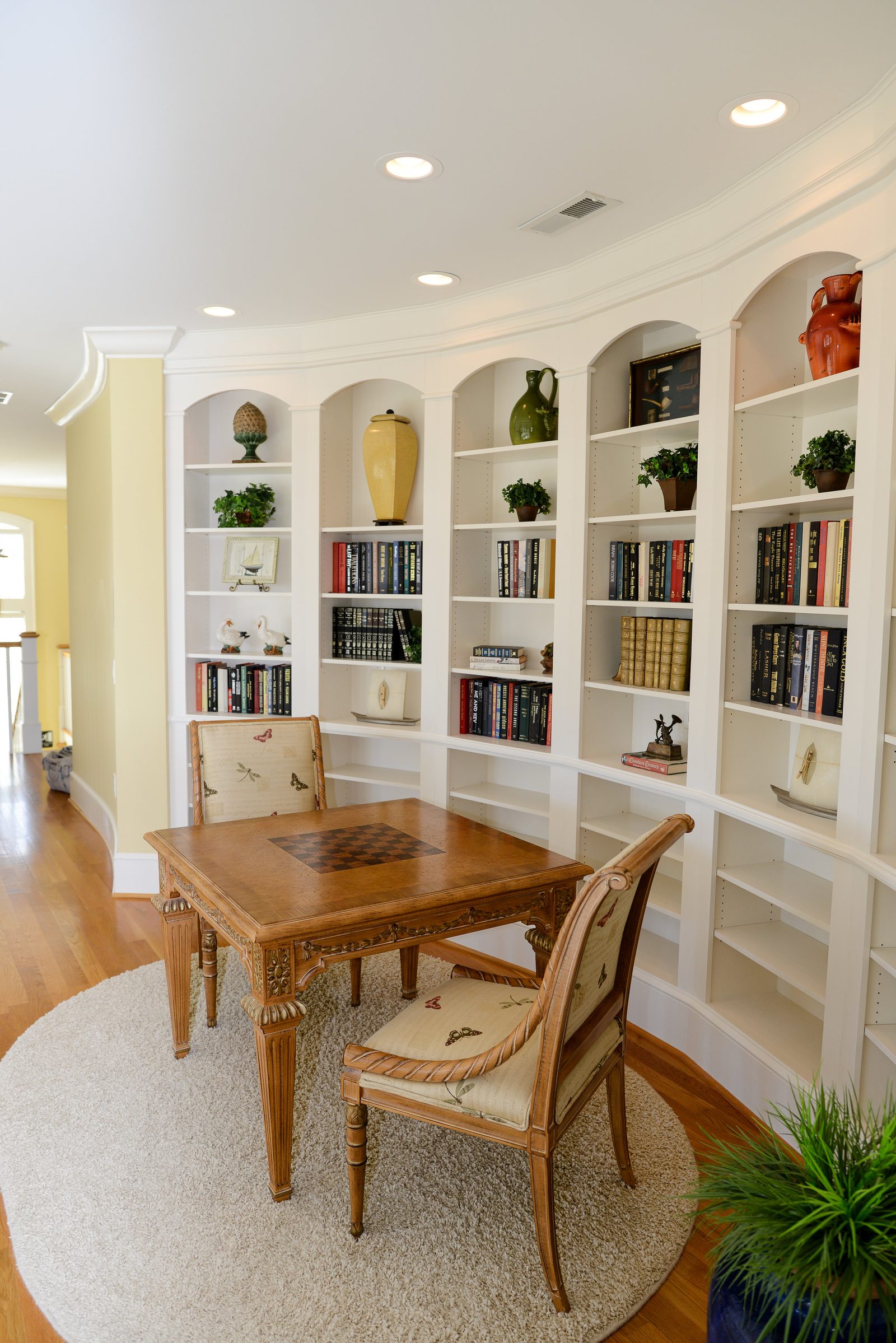 A library alcove with built-in bookshelves and a small games table