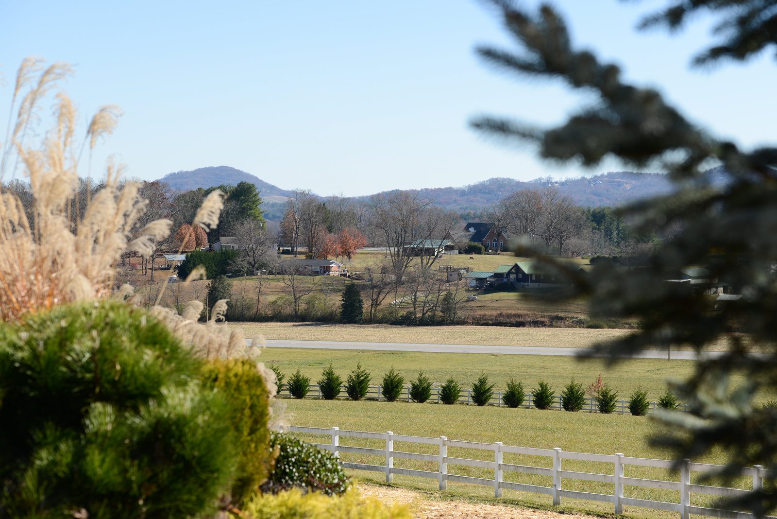 A view from the grounds across fenced pasture toward the mountains