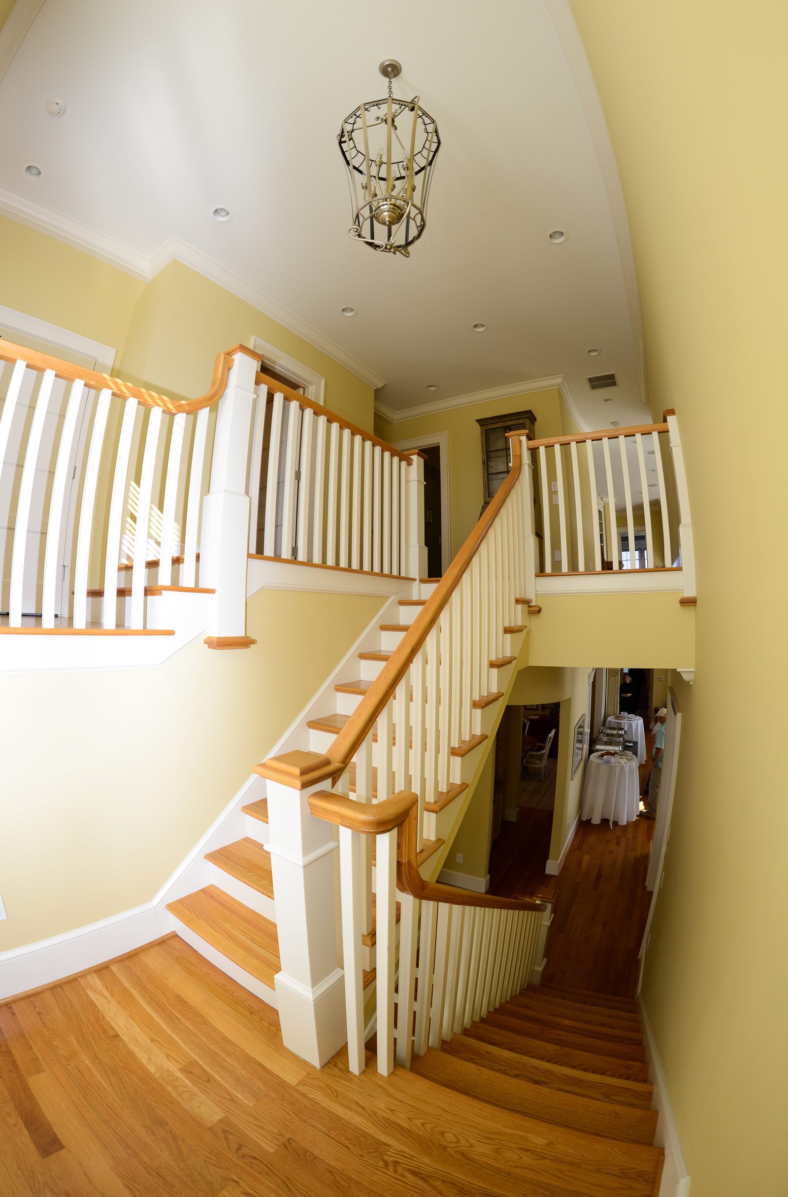 An open flight of stairs with a white railing overlooking the main floor (view 2)