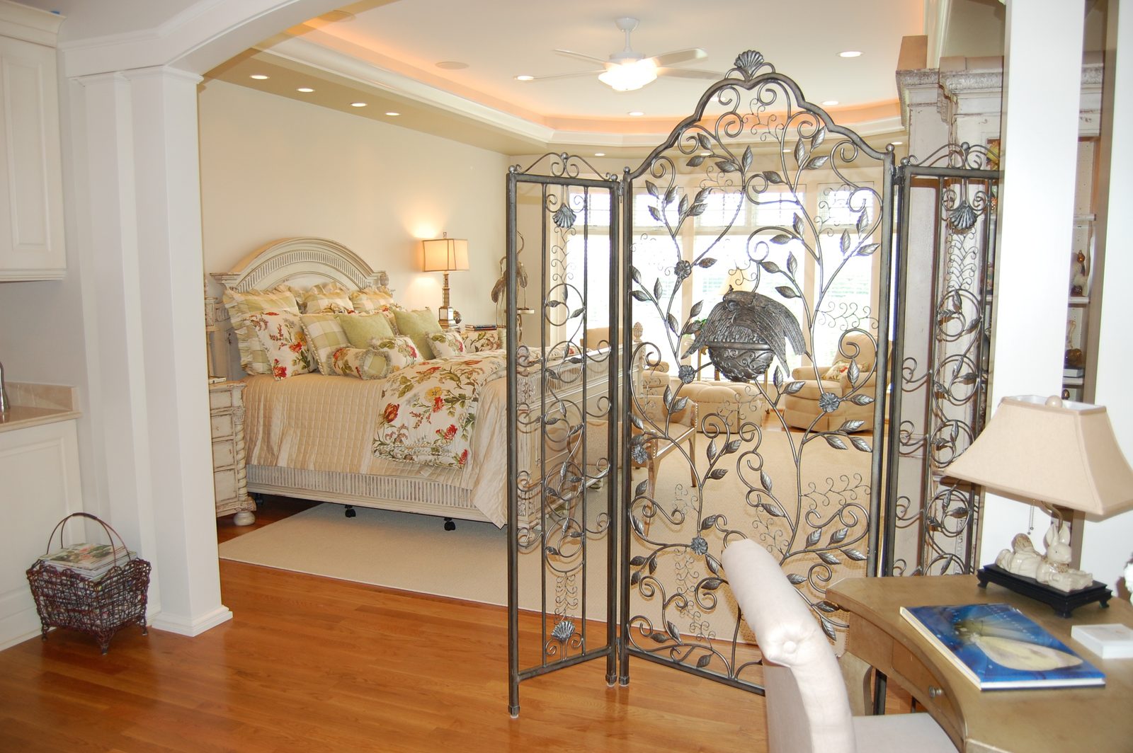 A suite with floral bedding, built-in cabinetry and a decorative iron partition (view 1)