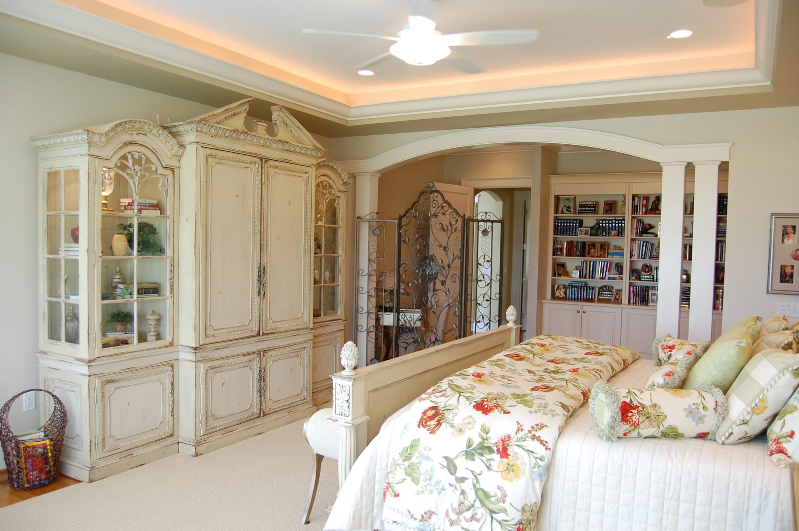 A suite with floral bedding, built-in cabinetry and a decorative iron partition (view 2)