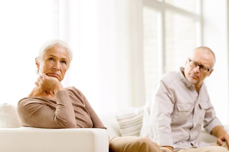 Unhappy older caucasian couple sitting on the couch