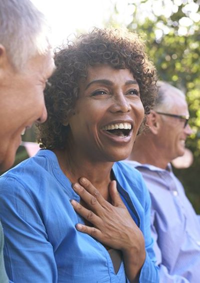 Close up of an African American woman smiling mid conversation with a caucasian adult male