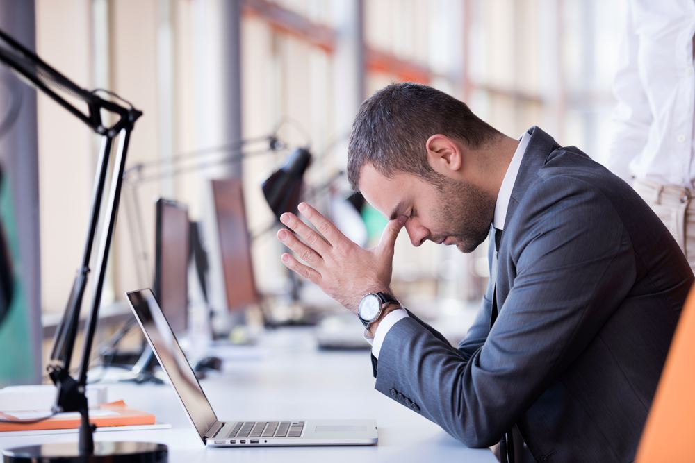 man-stitting-at-office-desk-feeling-stressed How to Handle Stress at Work and Keep Sobriety