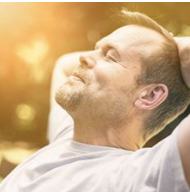 Adult caucasian male sitting on a bench relaxing with his head back and eyes closed