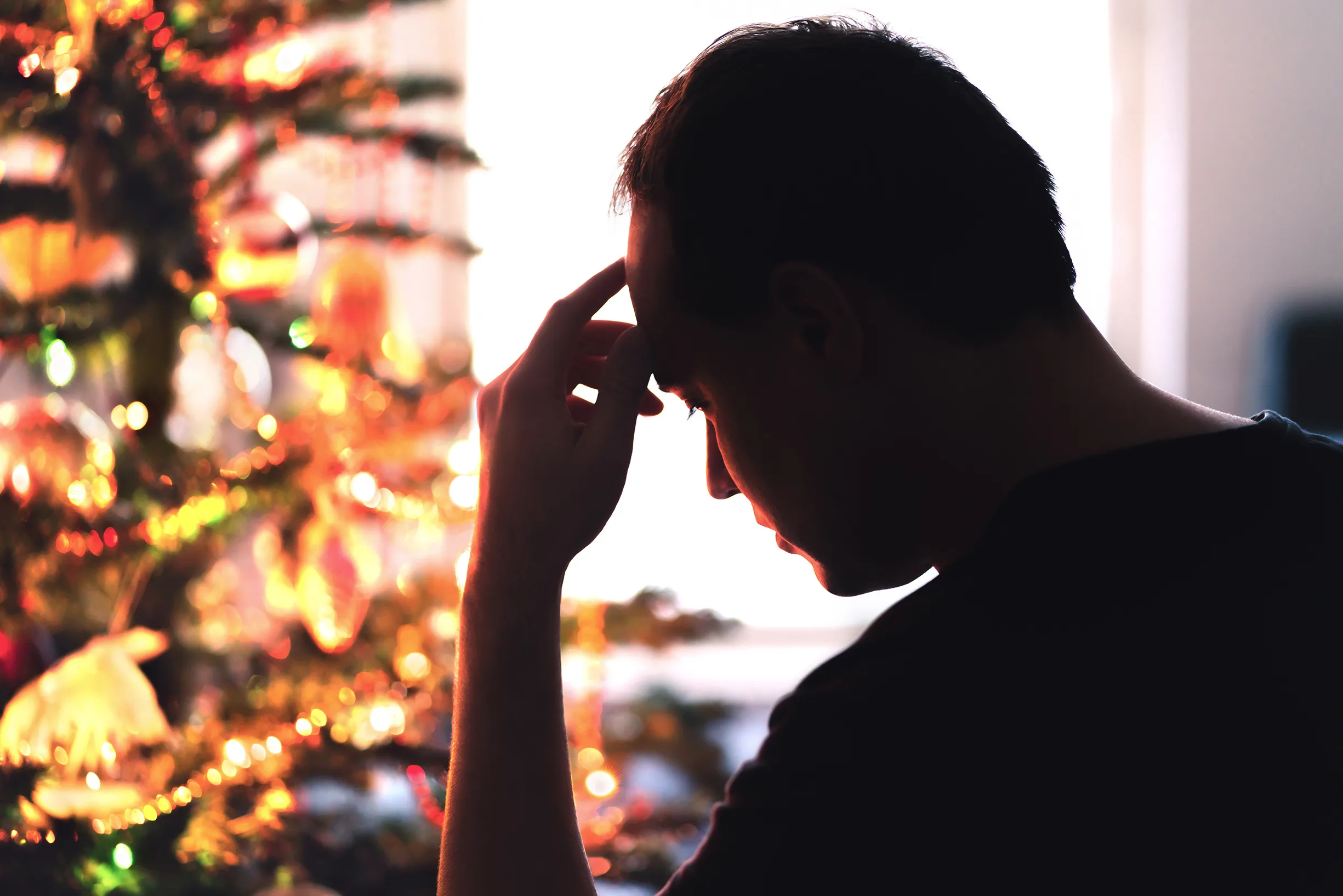 Sad on Christmas. Unhappy, lonely or tired man with stress, grief or depression. Family fight, loneliness, frustration or money problem on Xmas. Sick person with flu, pain and headache on holiday