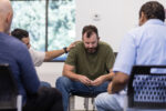 Man struggling with PTSD attending group therapy for treatment
