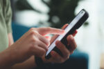 Close-up shot of female hands using smart phone for sobriety app