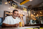 Sad man drinking beer on a bar