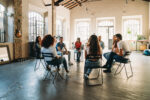 Group therapy AA meeting in progress with group of mixed young adults