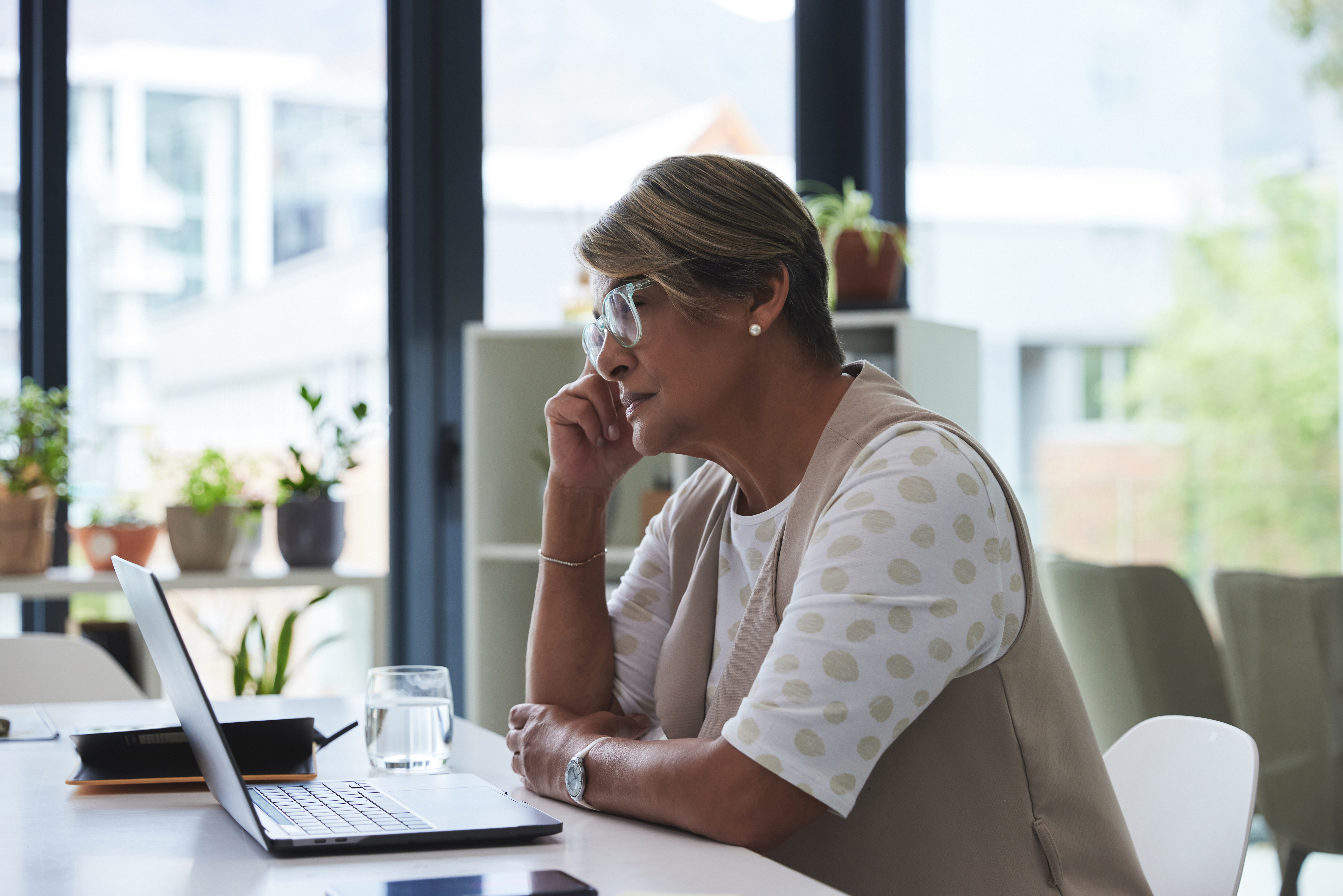 Laptop, thinking and tired old woman at desk, struggling with brain fog