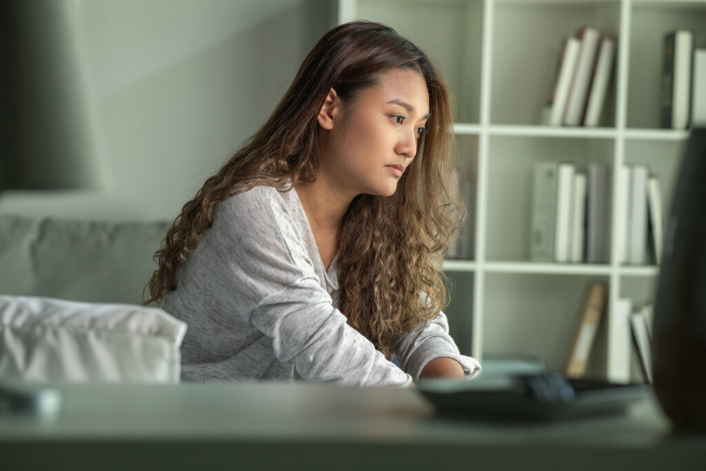 Young Asian woman sitting in a bedroom, feeling sad tired and worried suffering depression in mental health. in concept of depression anxiety and insomnia