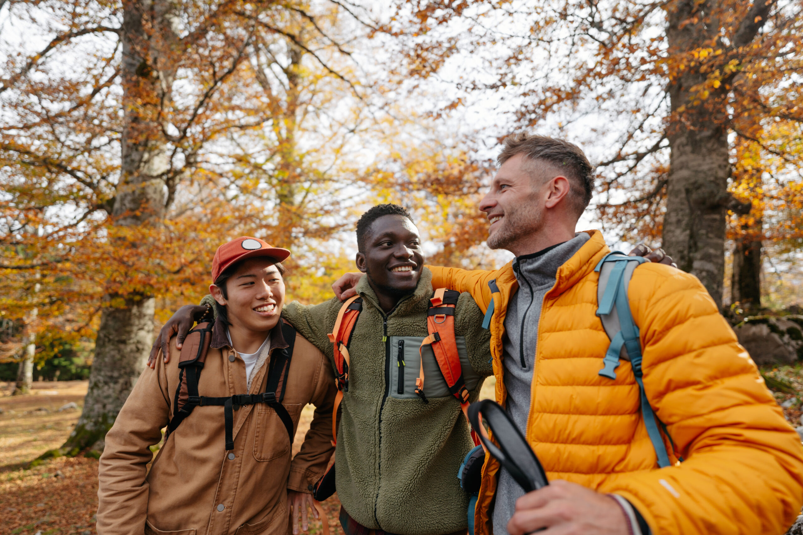 Photo of a diverse group of people, having a walk with backpacks through beautiful nature on a beautiful and sunny autumn day